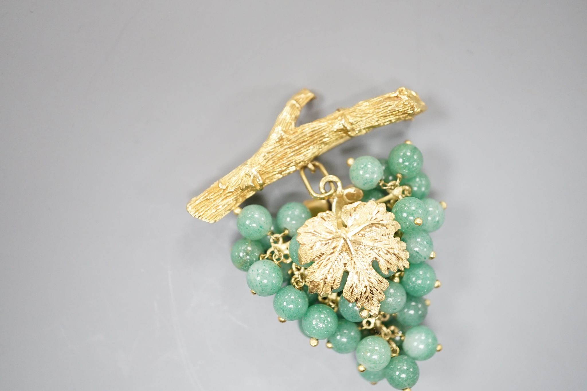 A 20th century continental 18k yellow metal and adventurine quartz bead set brooch, modelled as a bunch of grapes hanging from a branch, 59mm, gross weight 30.4 grams.